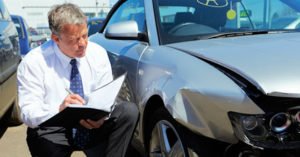 adjuster inspecting damage on a car